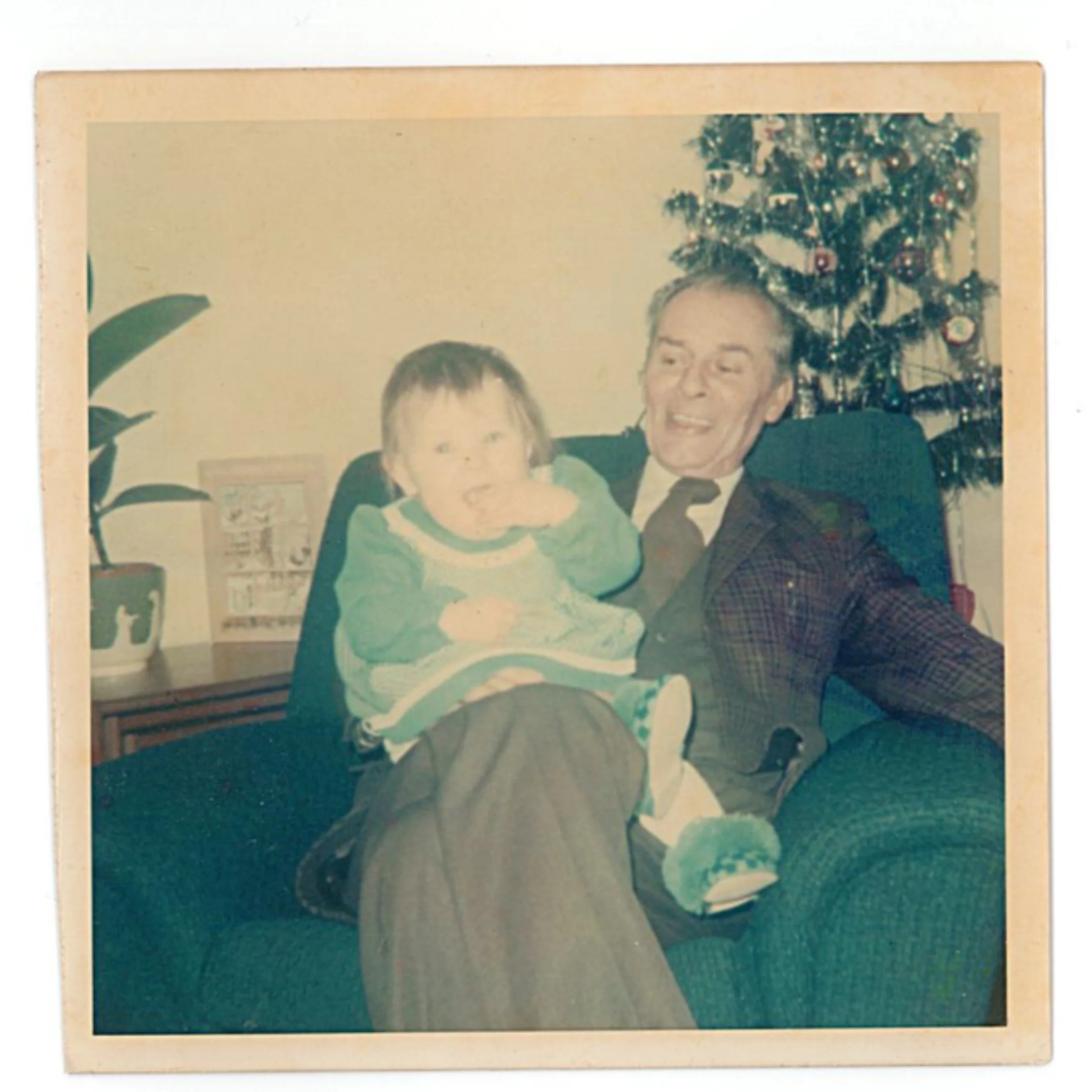 Margaret's father with his Granddaughter sitting on his lap. In the background you can see a Christmas tree.