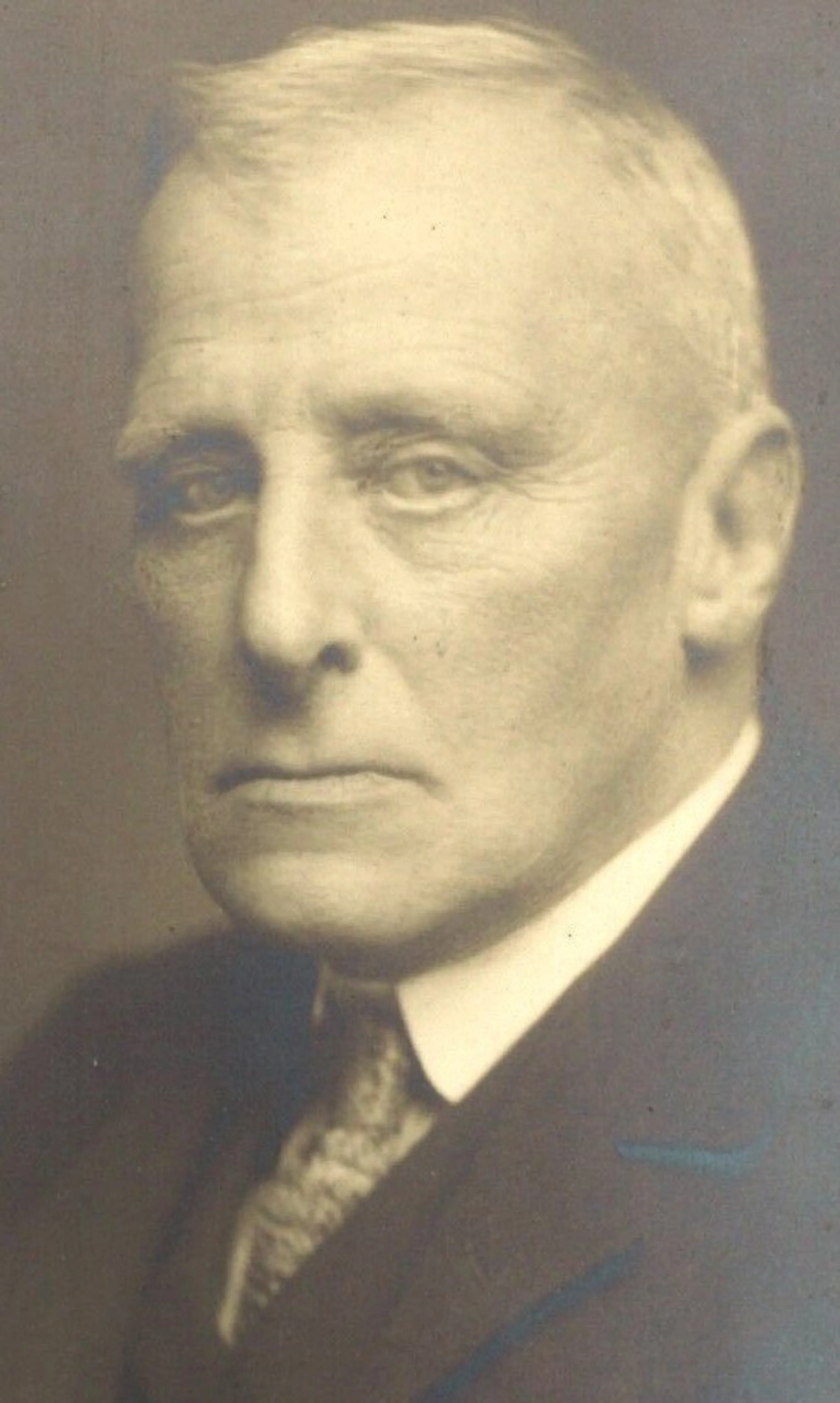 Charles Lupton in a vintage portrait photograph. He is wearing a suite and tie.