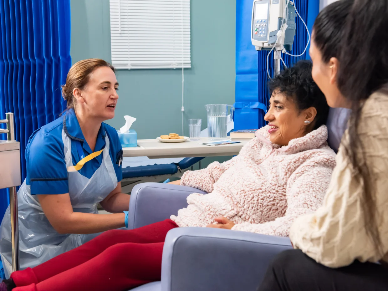Nurse talking to cancer patient and family members on a hospital ward