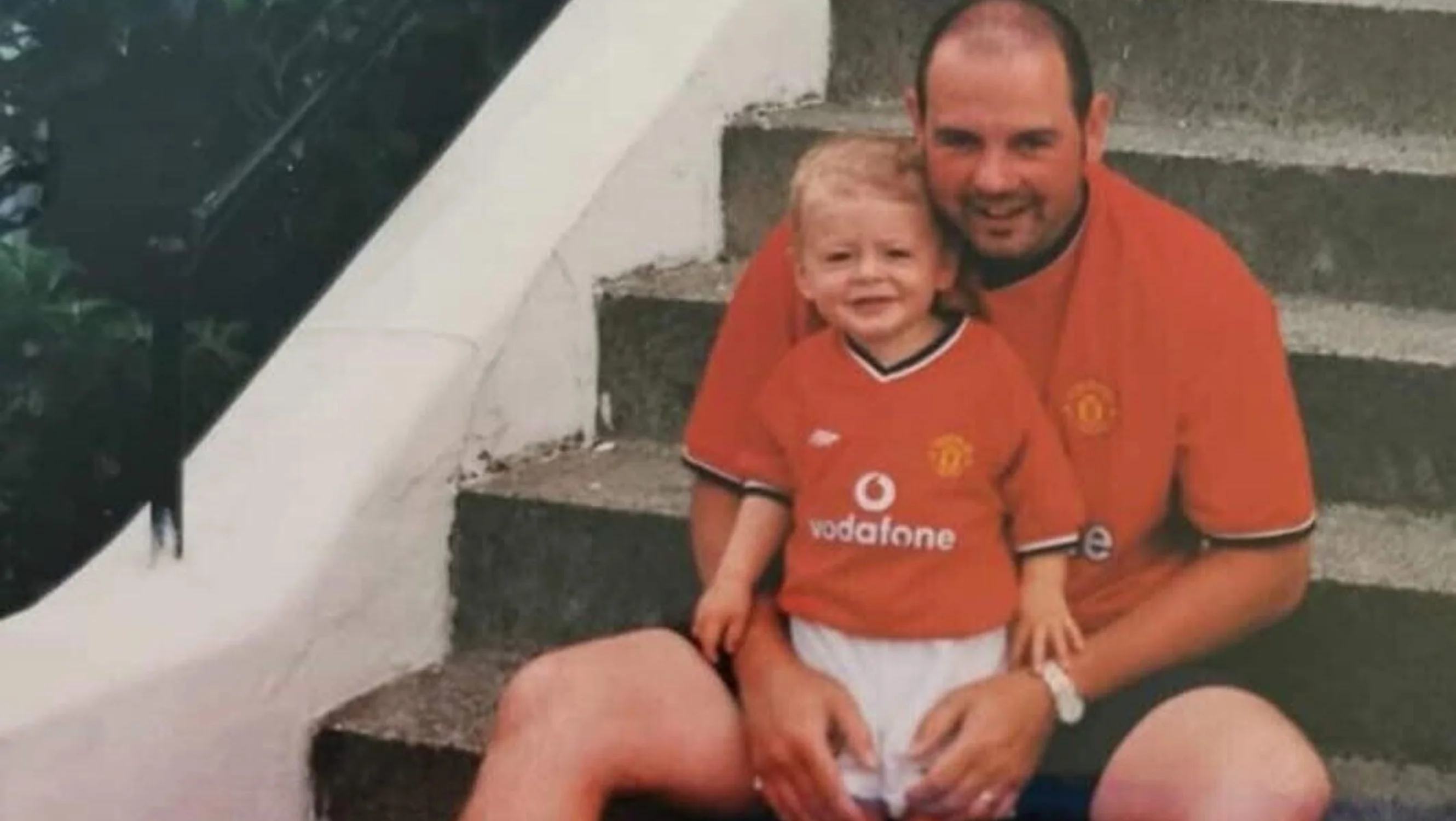 Lewis and his dad when hew was a small child. They are both wearing football kits
