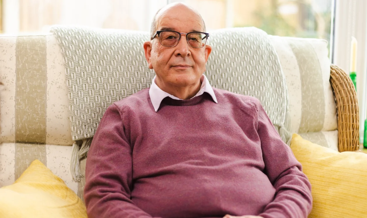 Pete Wheatstone sitting on sofa and smiling at camera