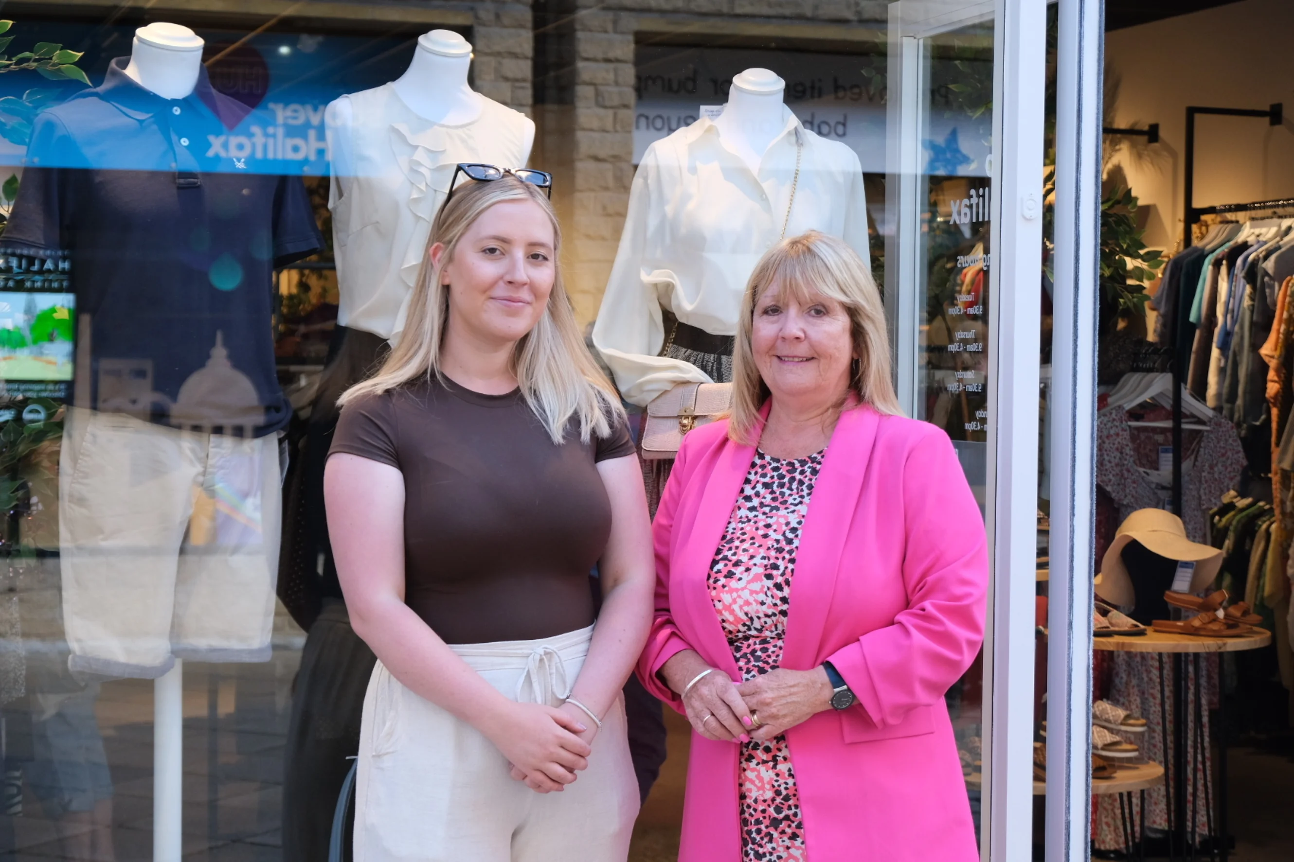 Alison and her daughter are stood outside the shop smiling.