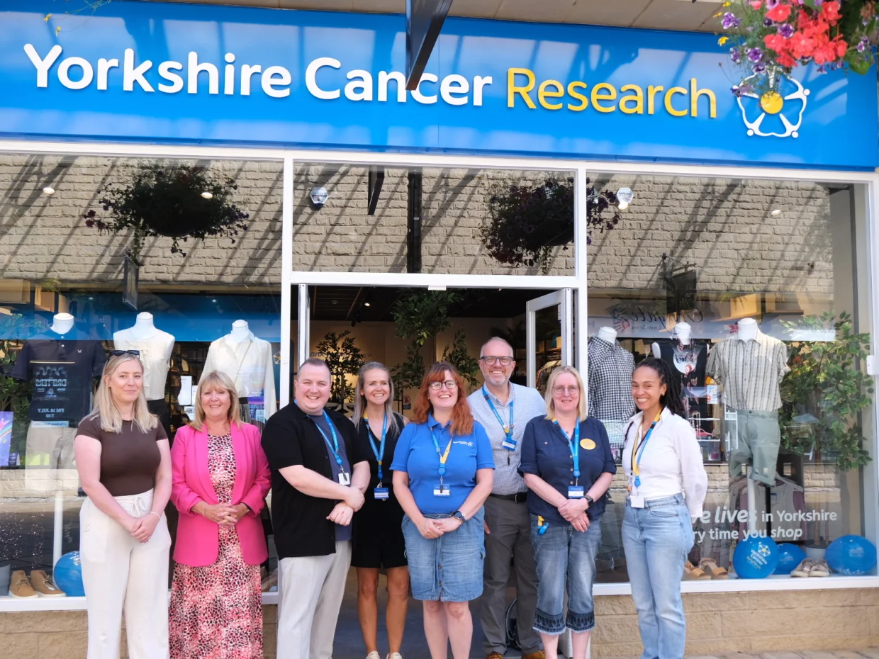 A row of eight people standing outside the Halifax shop smiling at the camera.