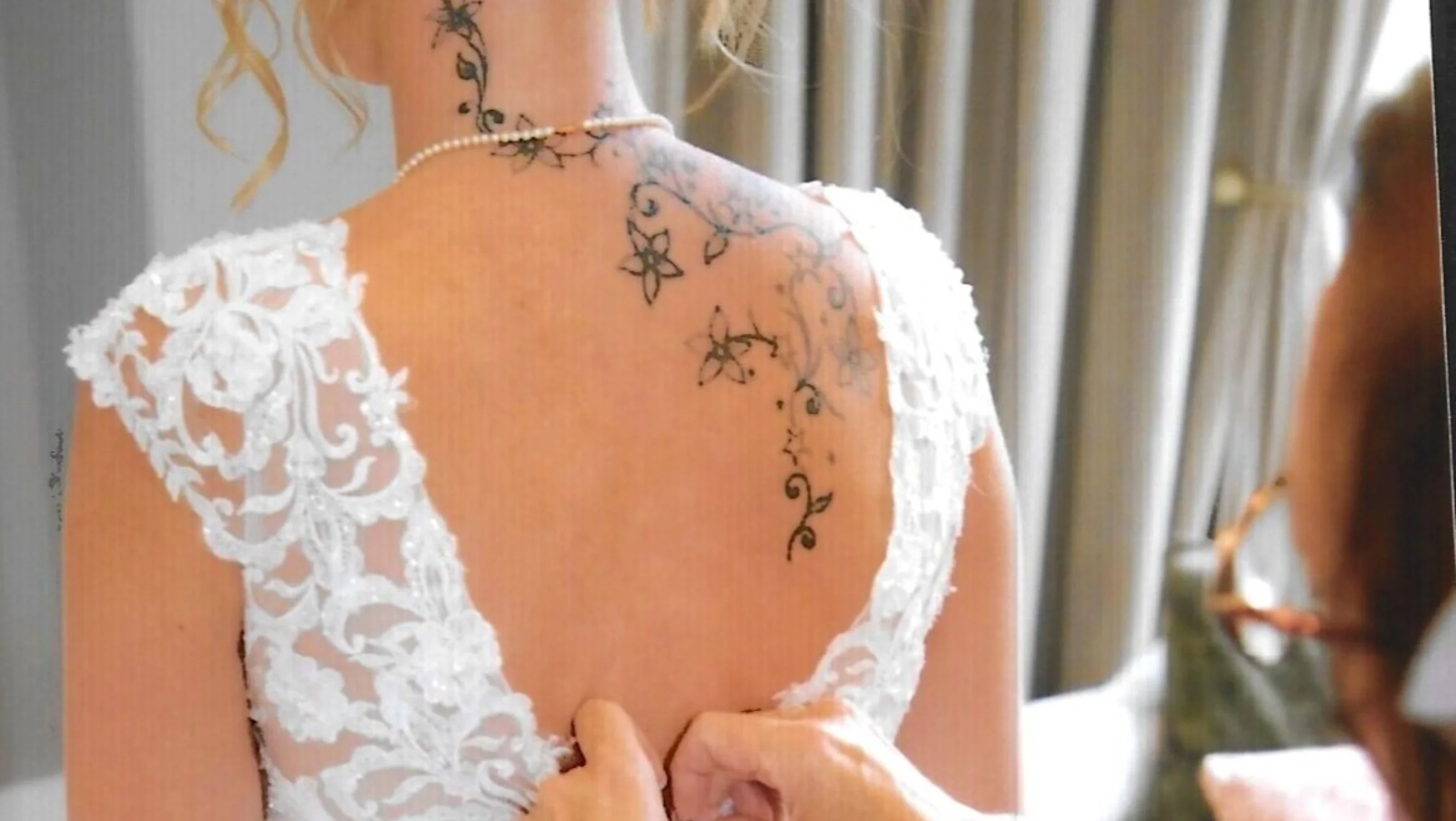 Back of a wedding dress getting fastened