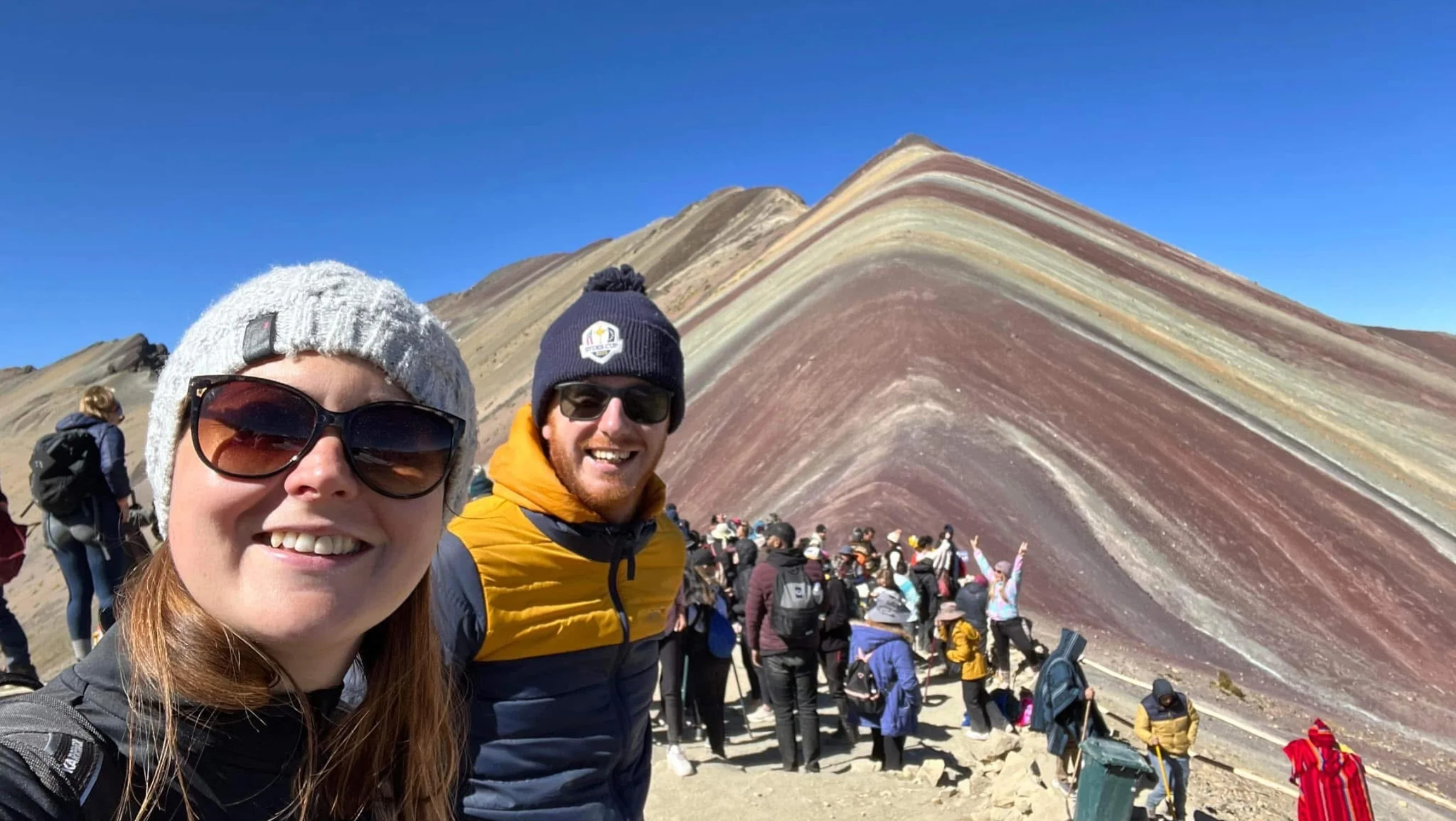 A man and a woman have a selfie on the rainbow mountains, Peru.