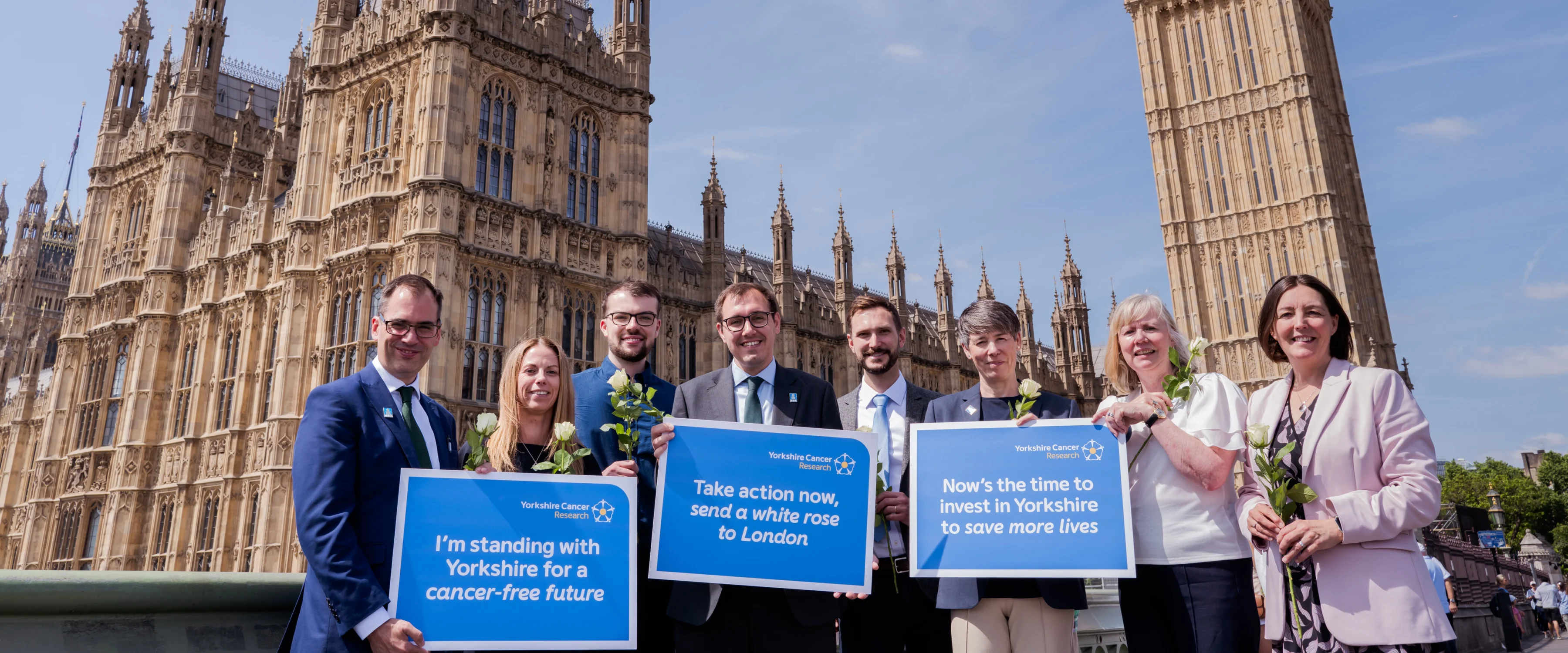 Cancer researchers, people affected by cancer, charity representatives and supporting politicians standing outside of Parliament