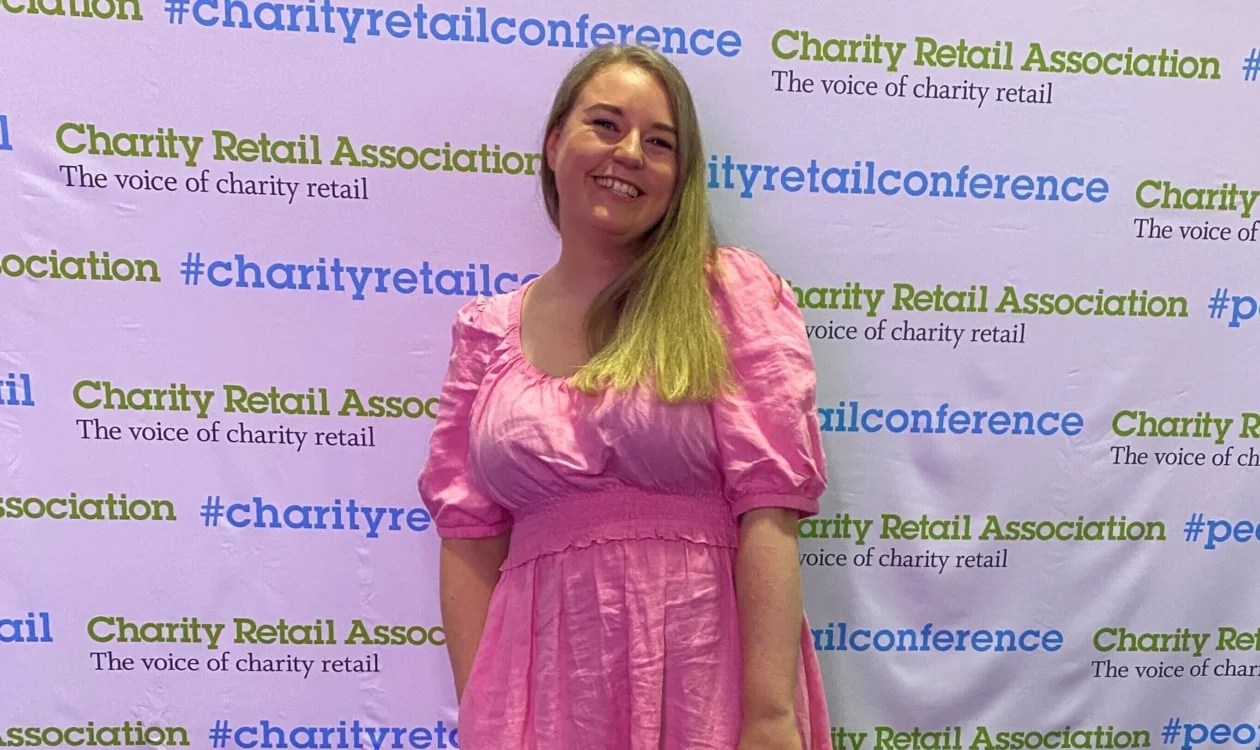 Aimee standing in front of the Charity Retail Association Conference wall