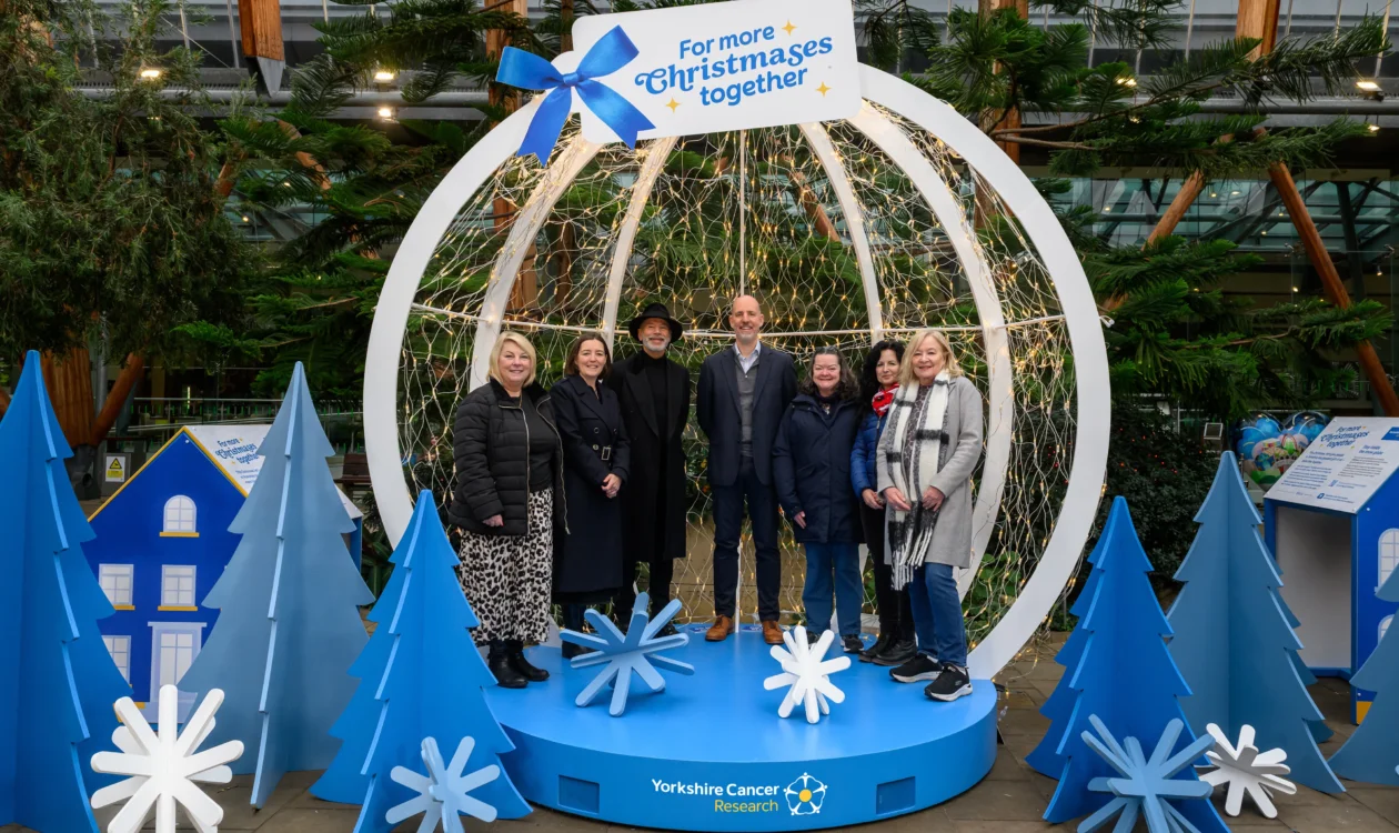 Supporters, researchers and people affected by cancer gather in front of the snow globe to help give families in Yorkshire more time together
