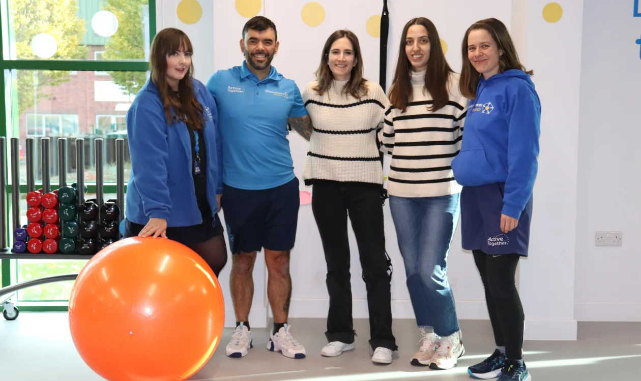 A group of people stand in a gym