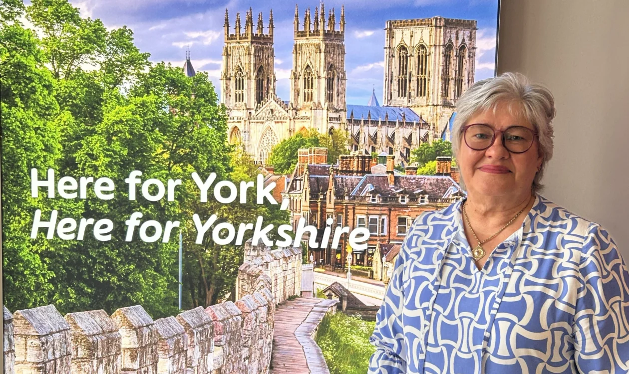 Woman standing in front of a display with text "Here for York, Here for Yorkshire"