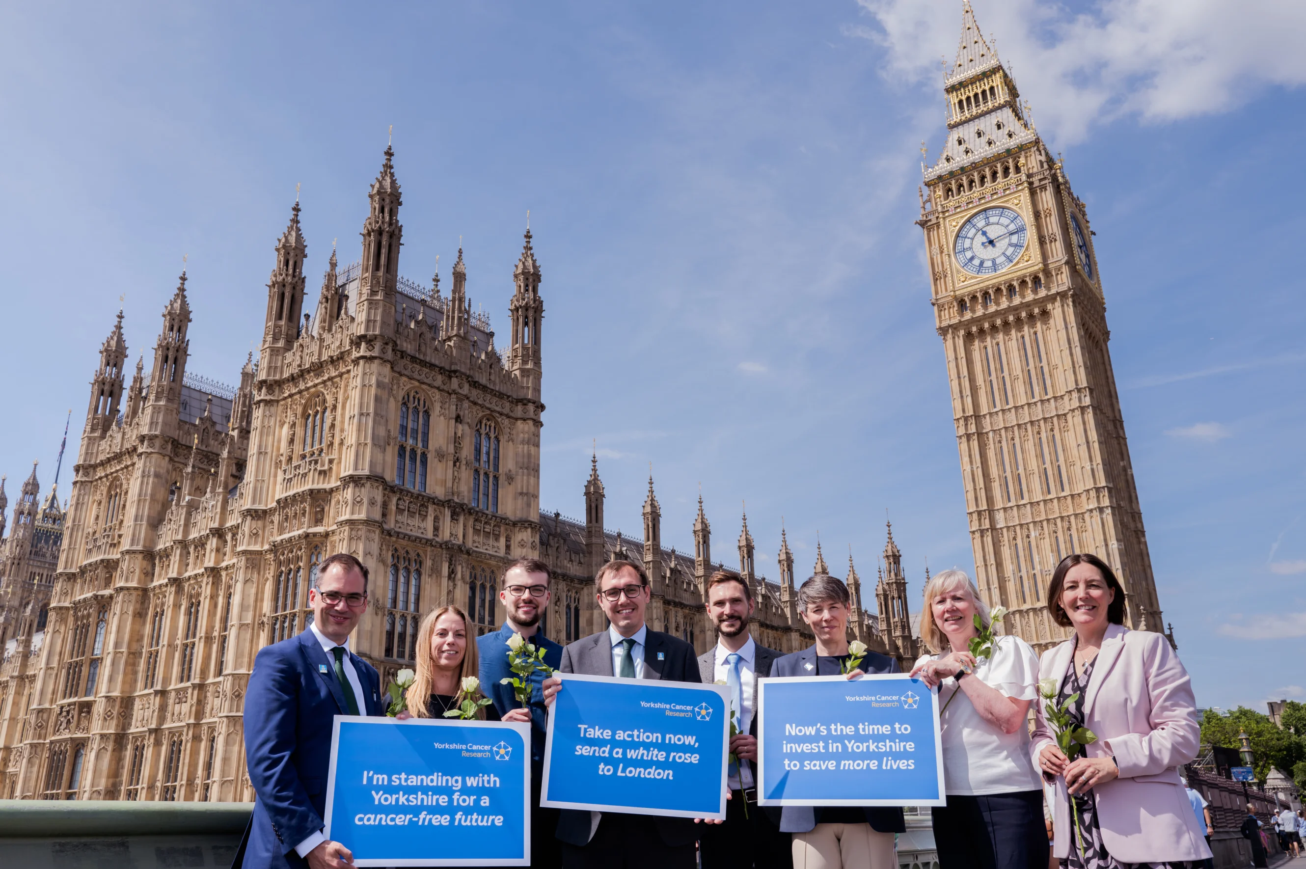 Cancer researchers, people affected by cancer, charity representatives and supporting politicians standing outside of Parliament