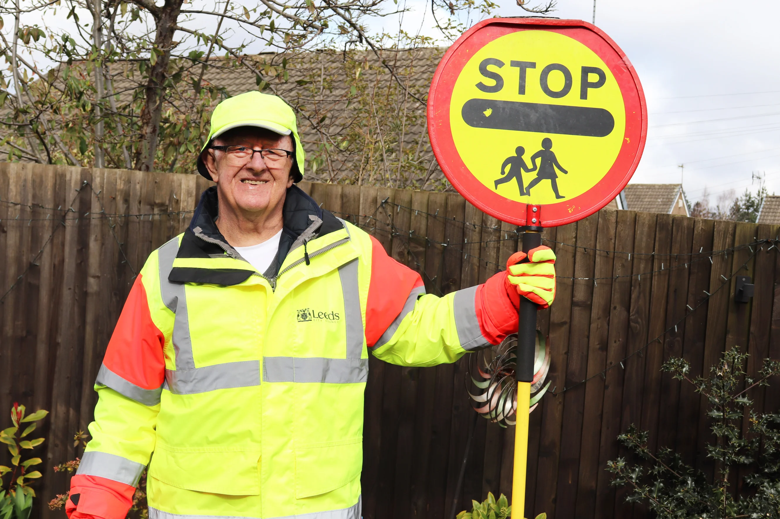 Ernest standing in his lollypop man uniform with a stop sign
