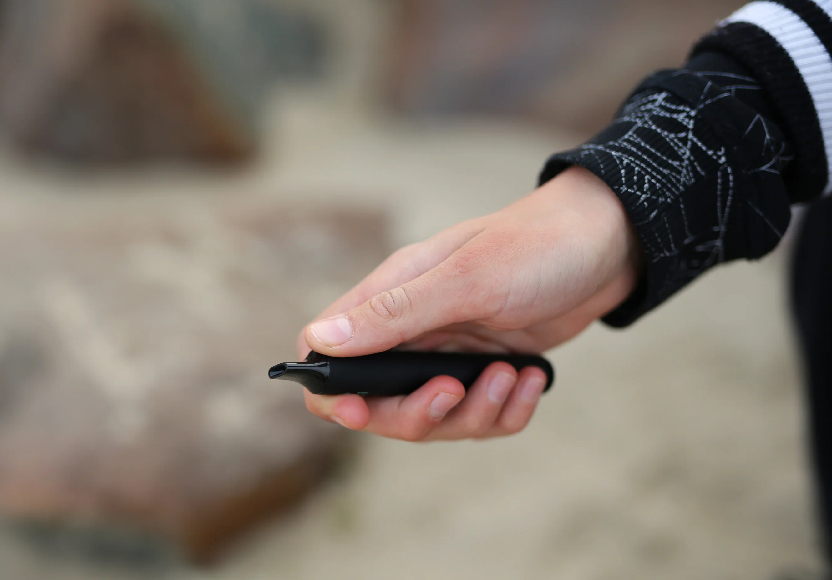 Young person holding a vape