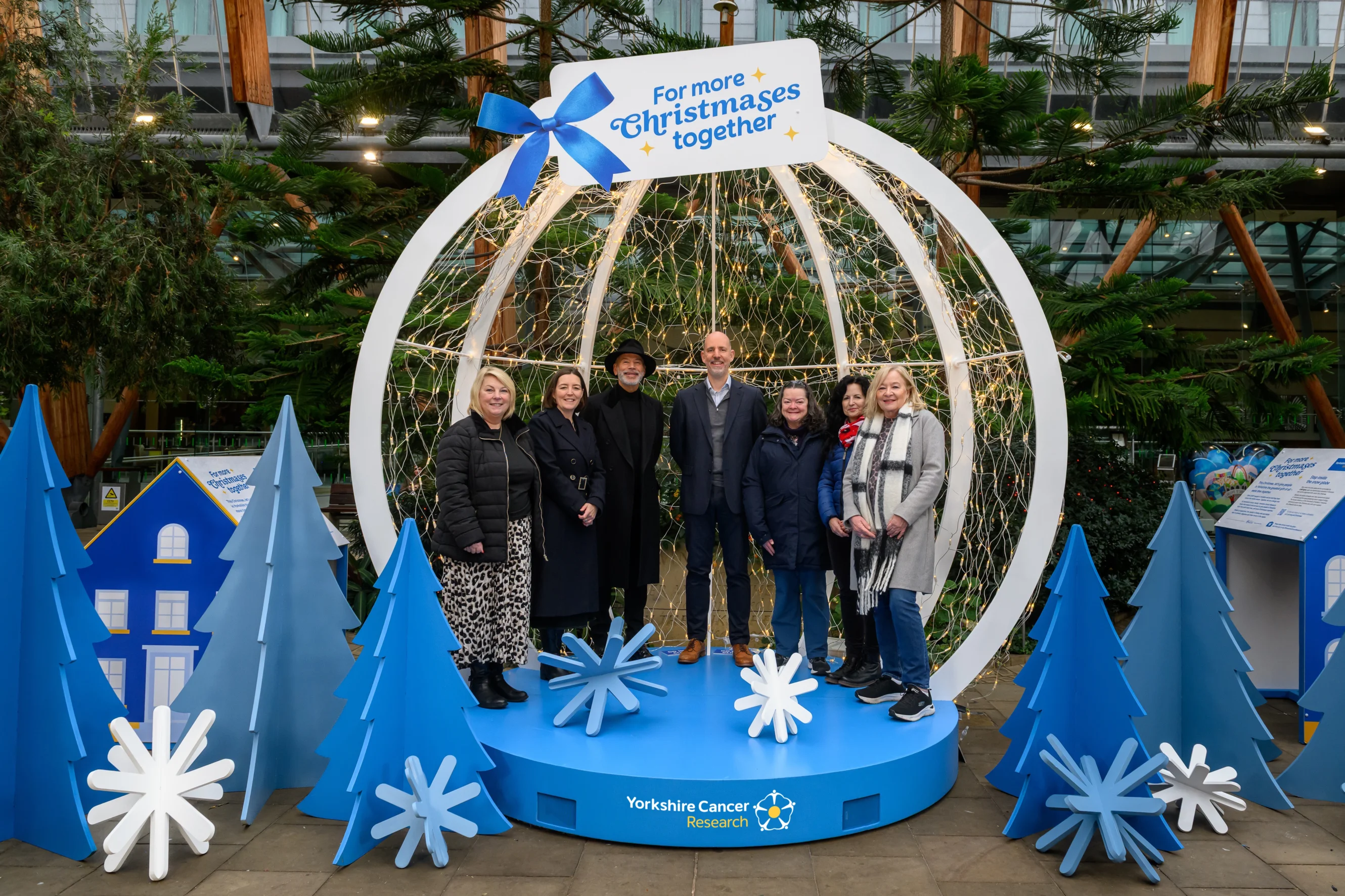 Supporters, researchers and people affected by cancer gather in front of the snow globe to help give families in Yorkshire more time together