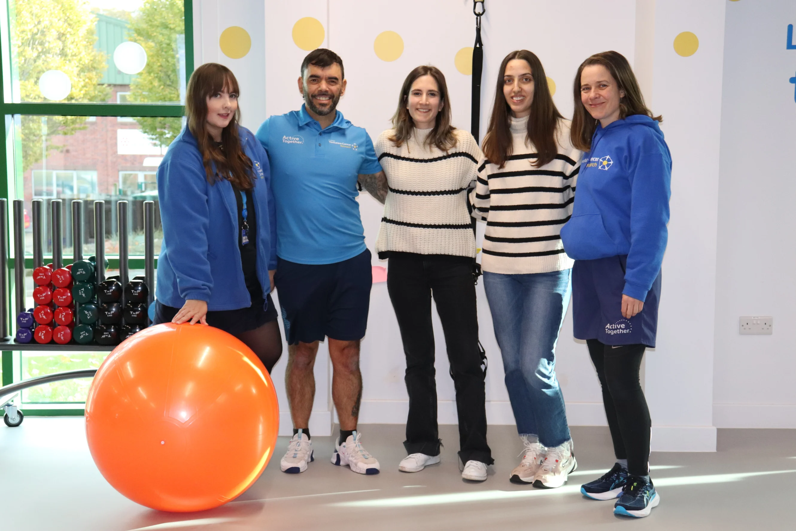 A group of people stand in a gym