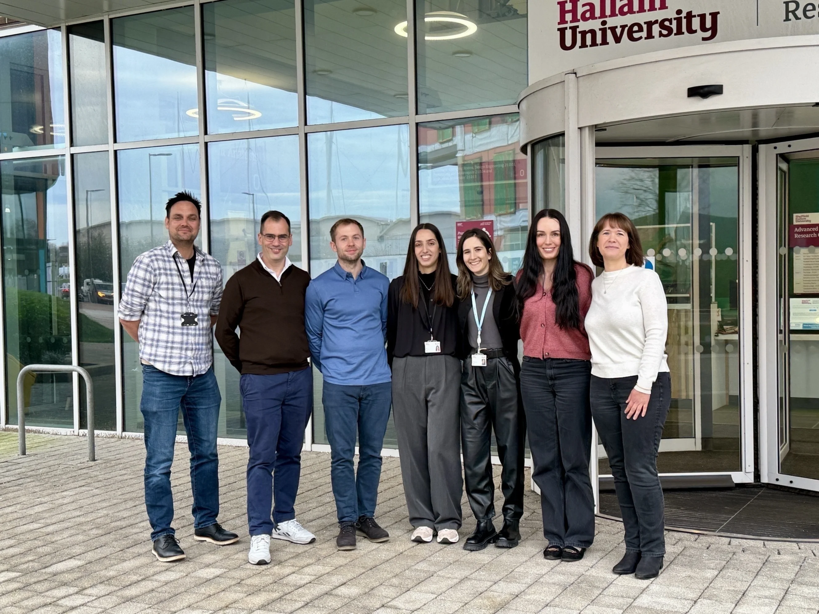 A group of people stand outside the AWRC at Sheffield Hallam University