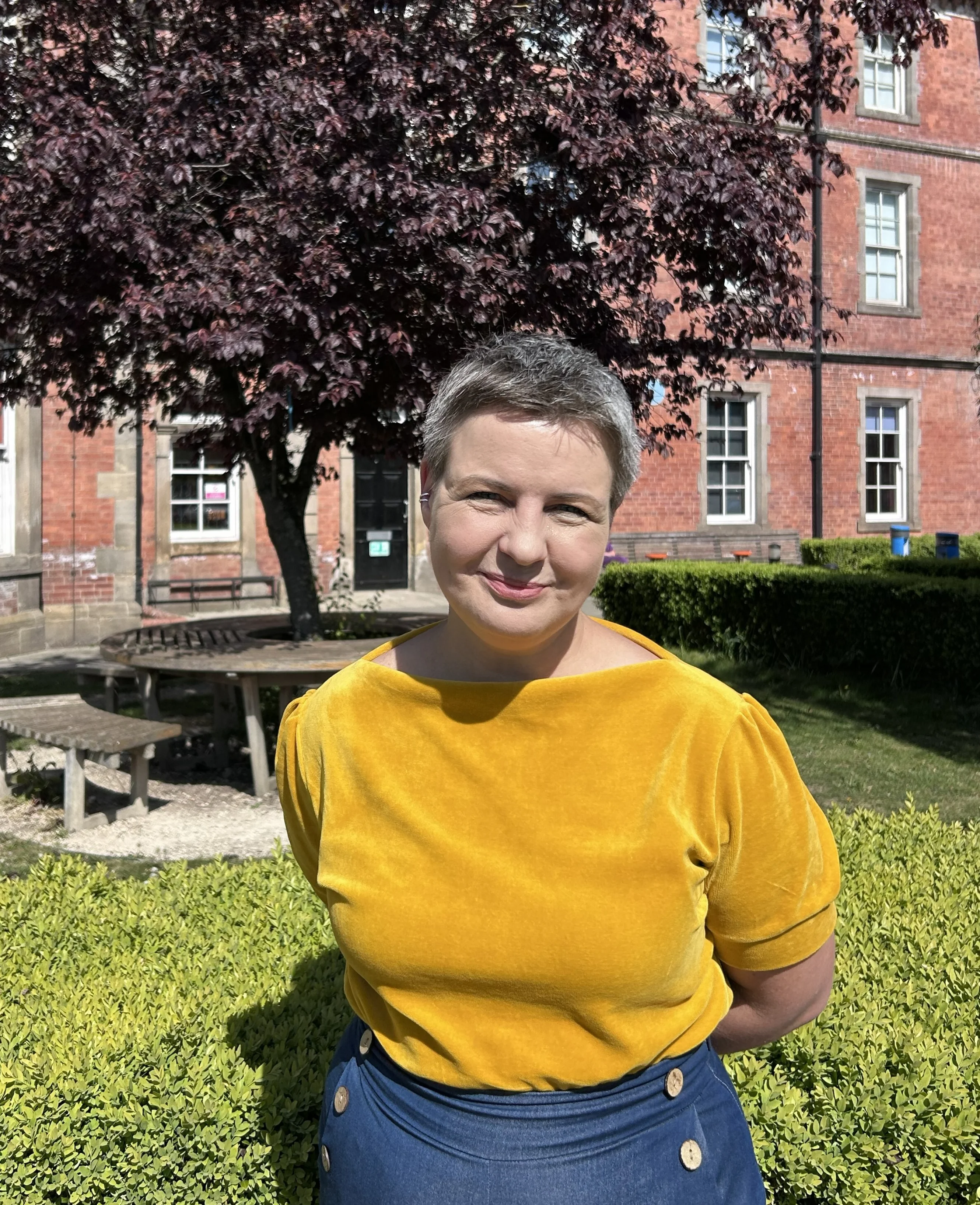 Woman standing on a field at a campus.