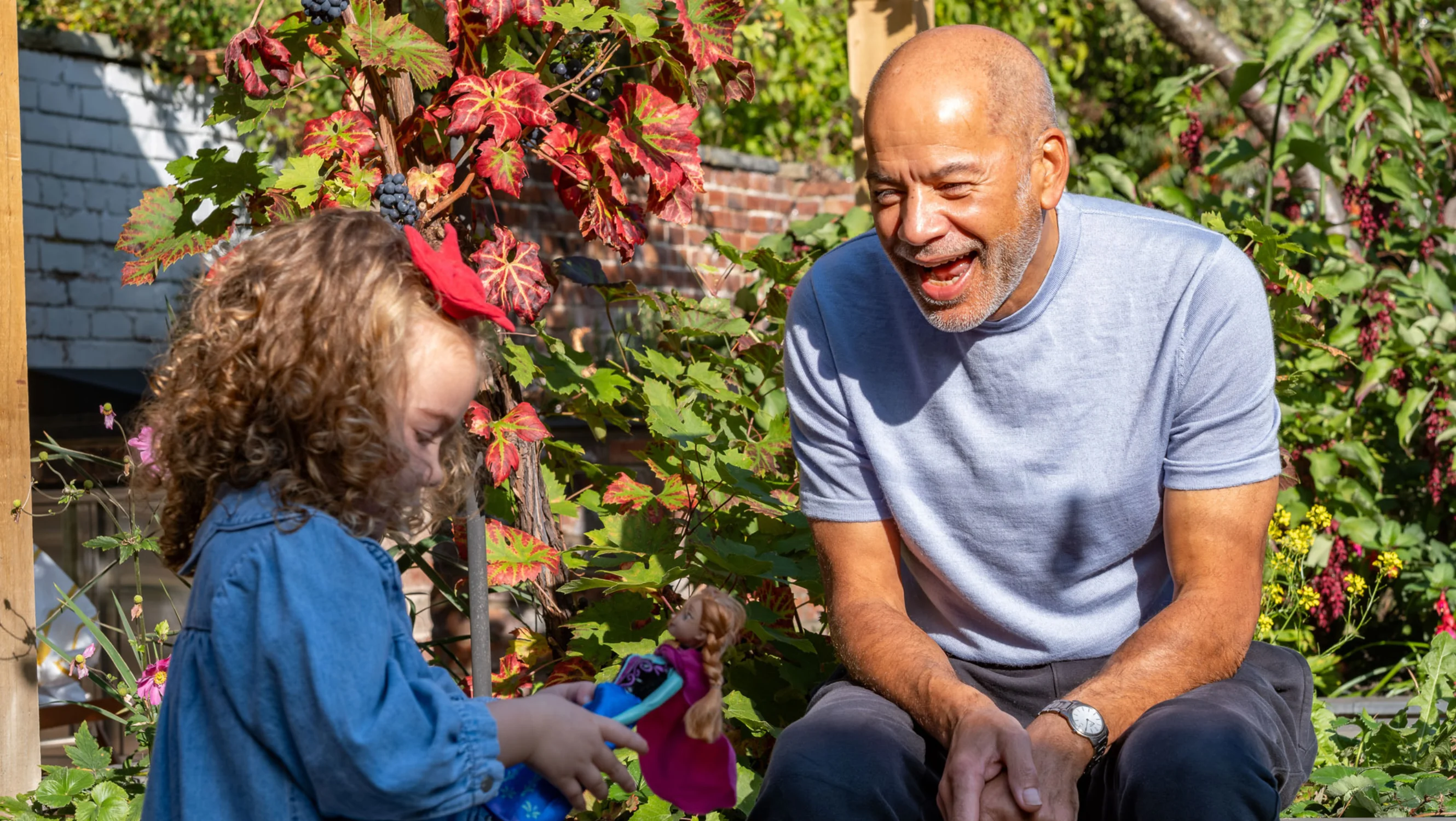 Russell playing with his granddaughter Florence outdoors