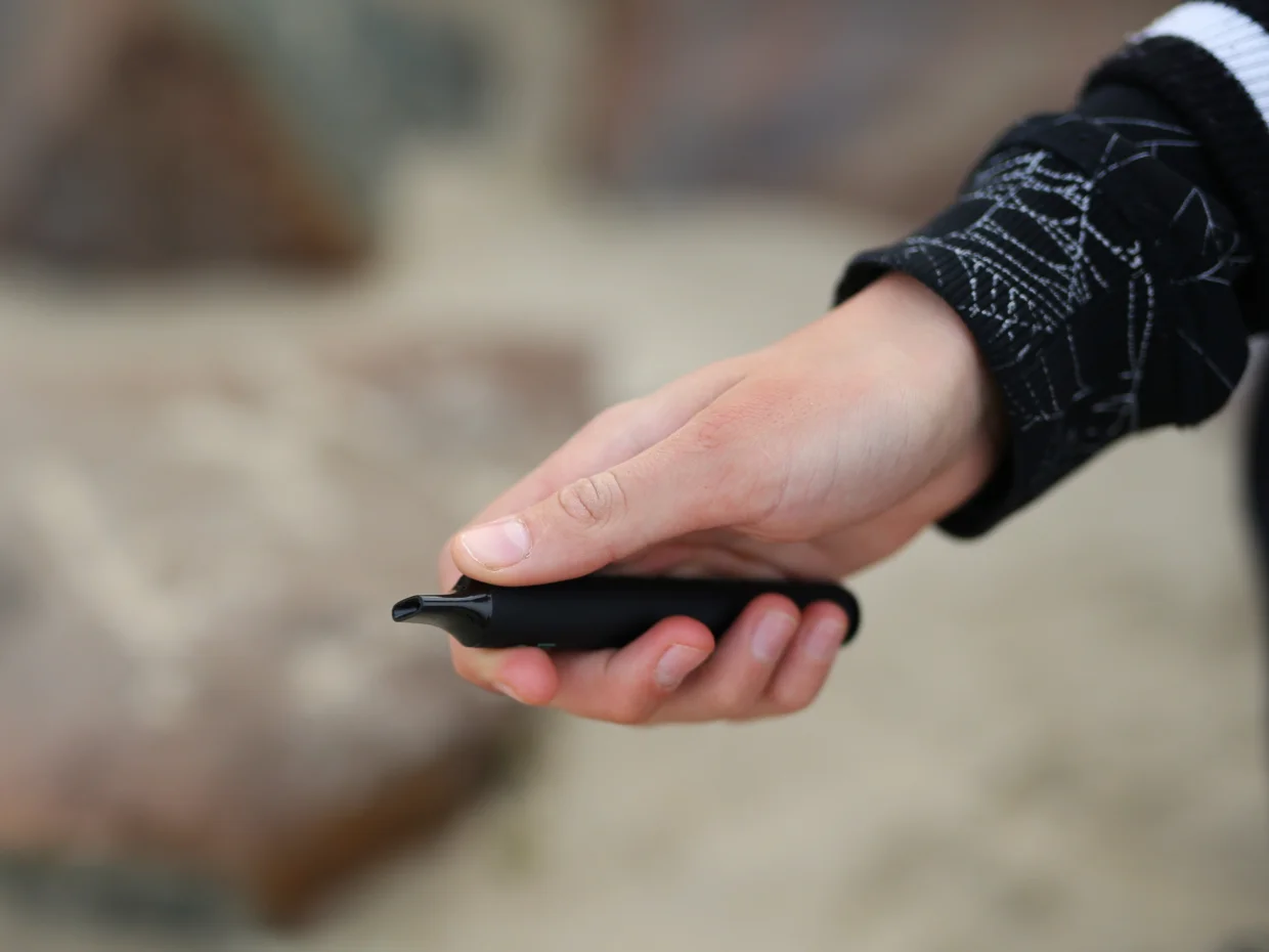 Young person holding a vape