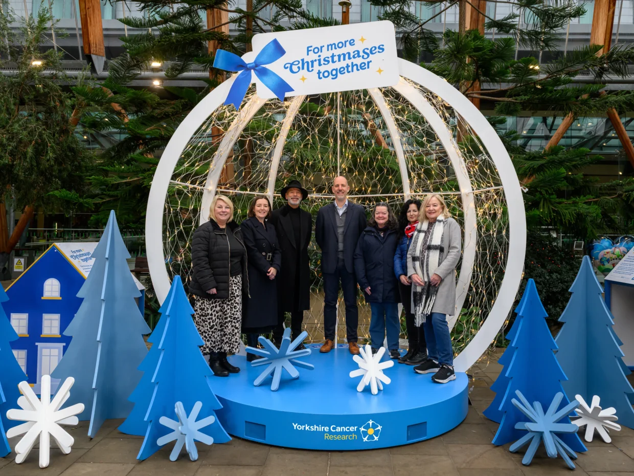 Supporters, researchers and people affected by cancer gather in front of the snow globe to help give families in Yorkshire more time together