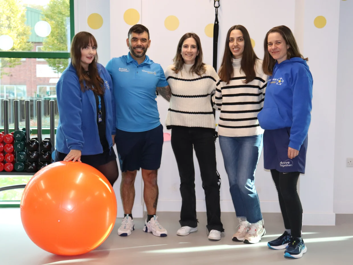 A group of people stand in a gym