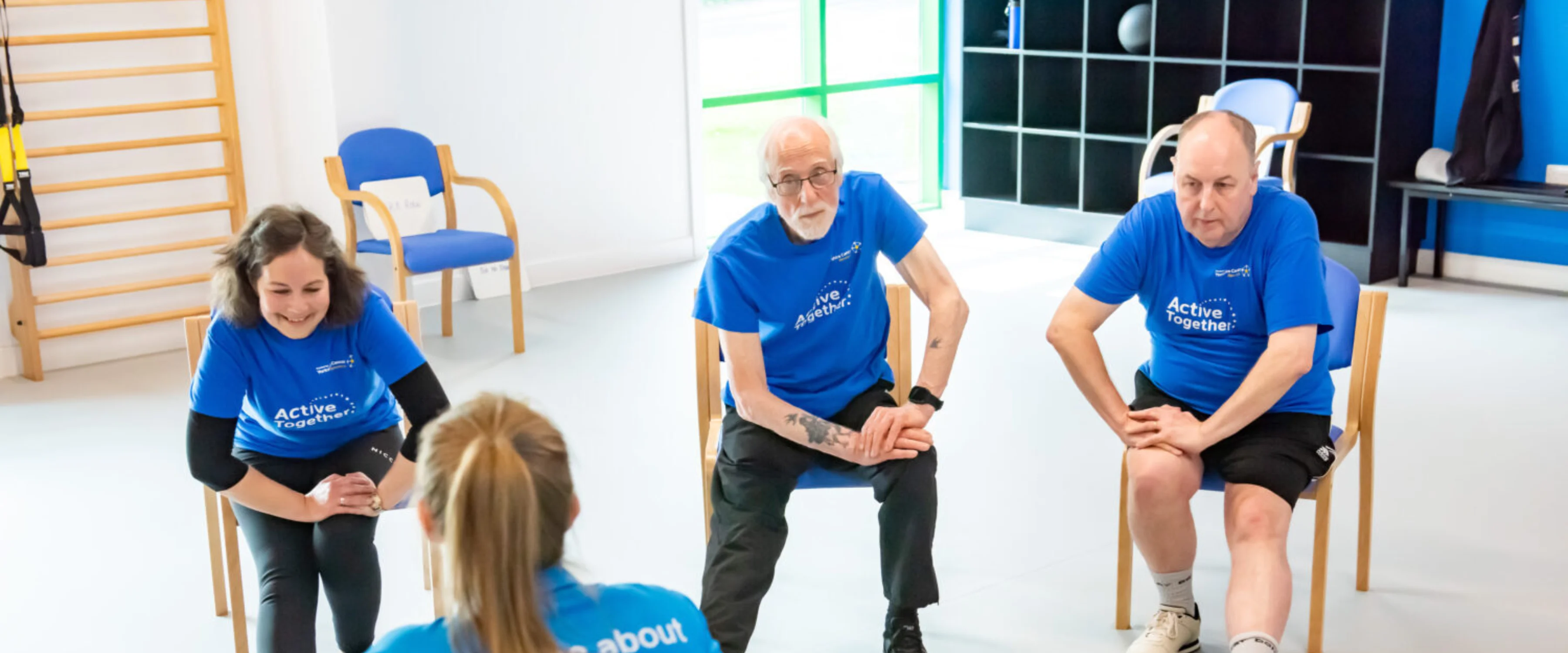 Four people stretching in a gym studio