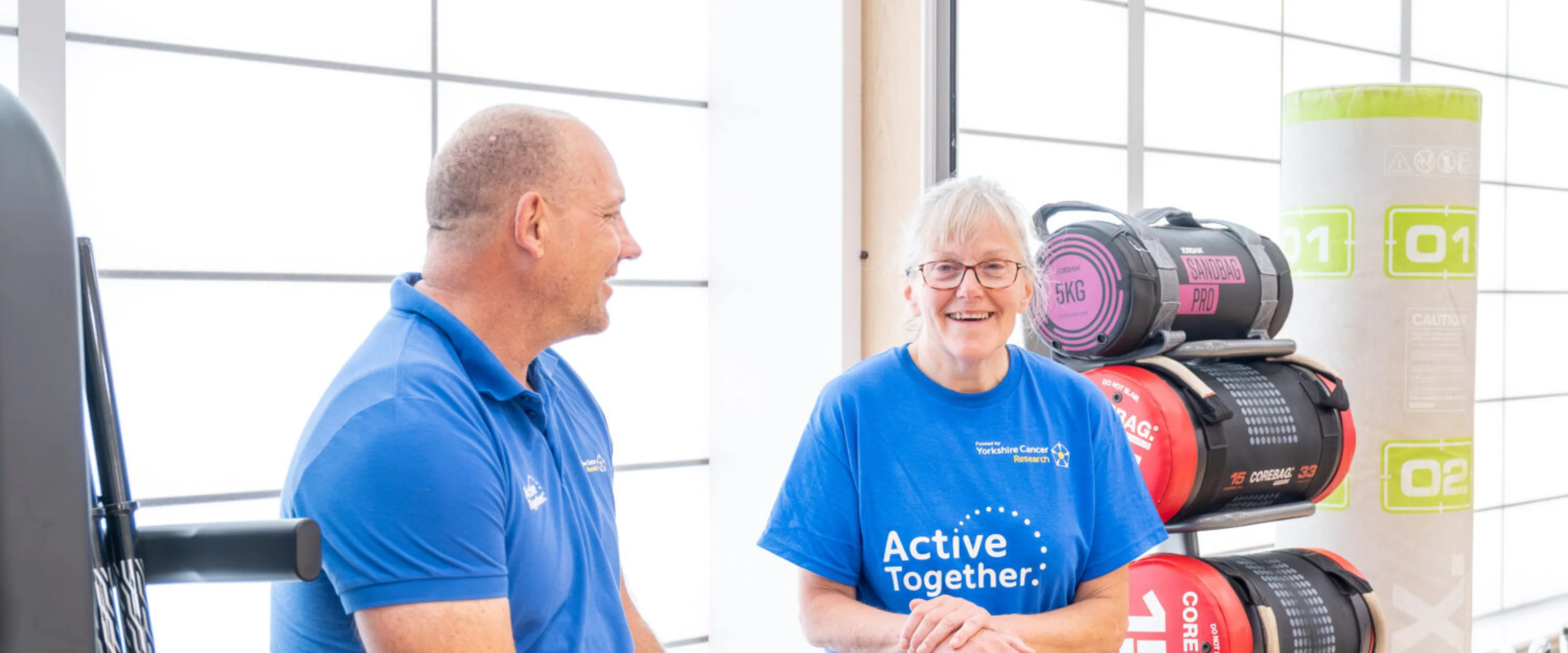 Two people in a gym dressed in blue