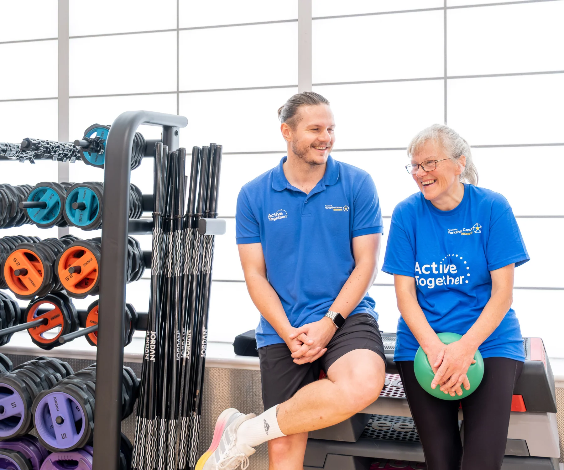 Two people wearing blue in a gym studio