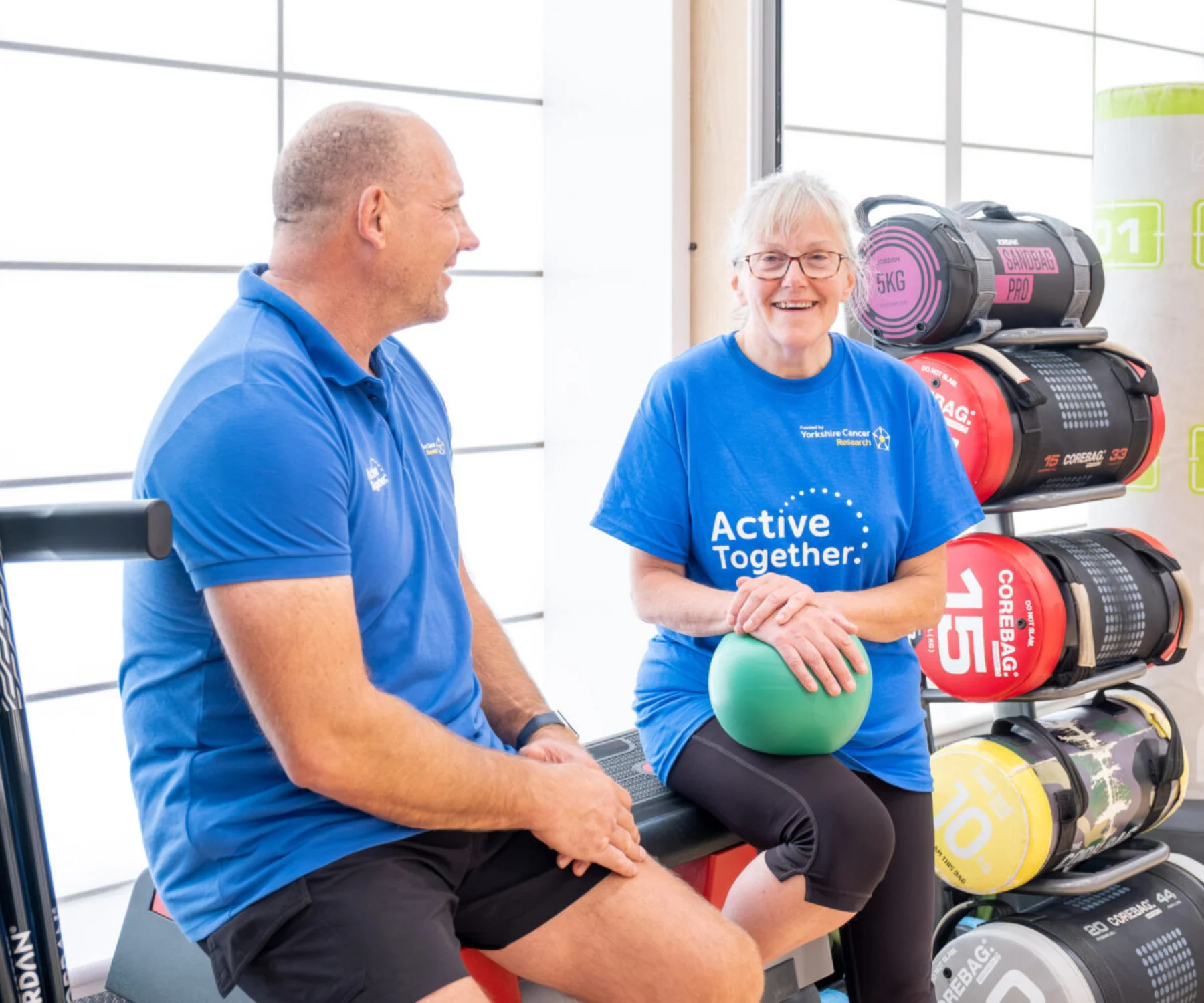 Two people in a gym dressed in blue