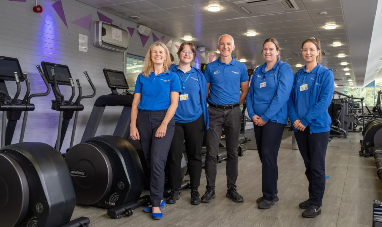 A team of people in blue standing in a gym