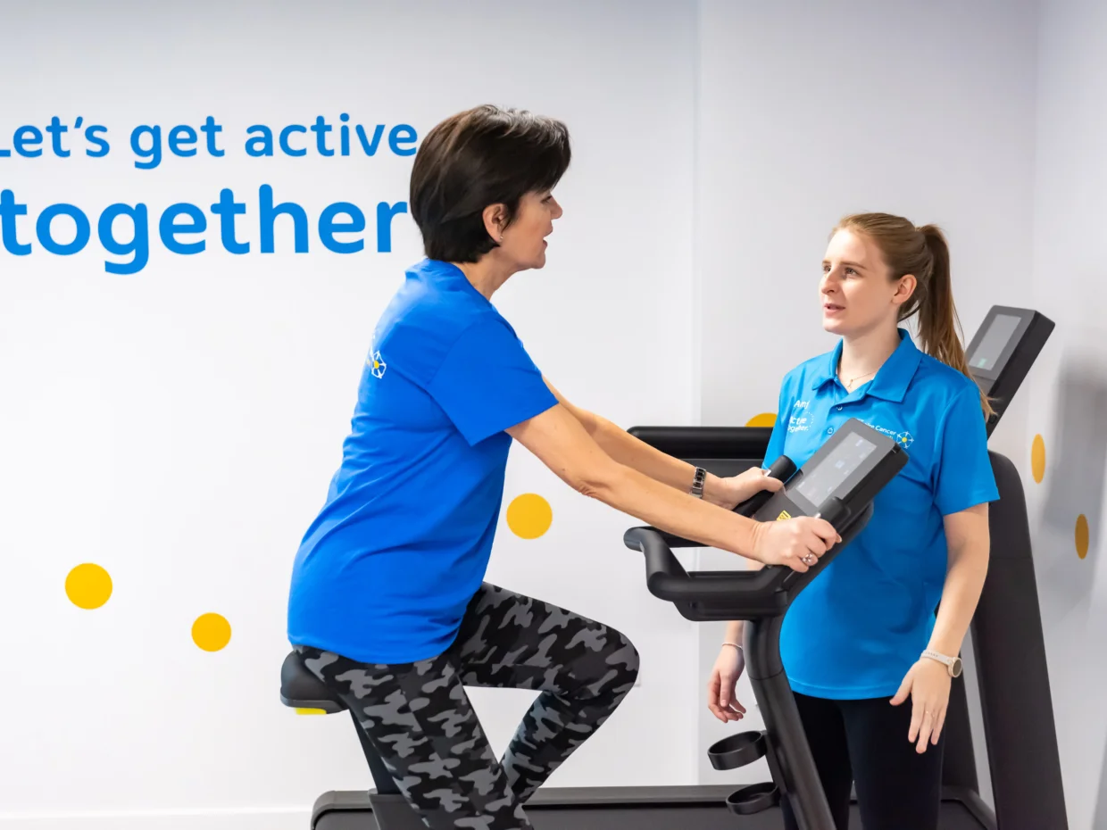 A woman on an indoor bike with a fitness instructor