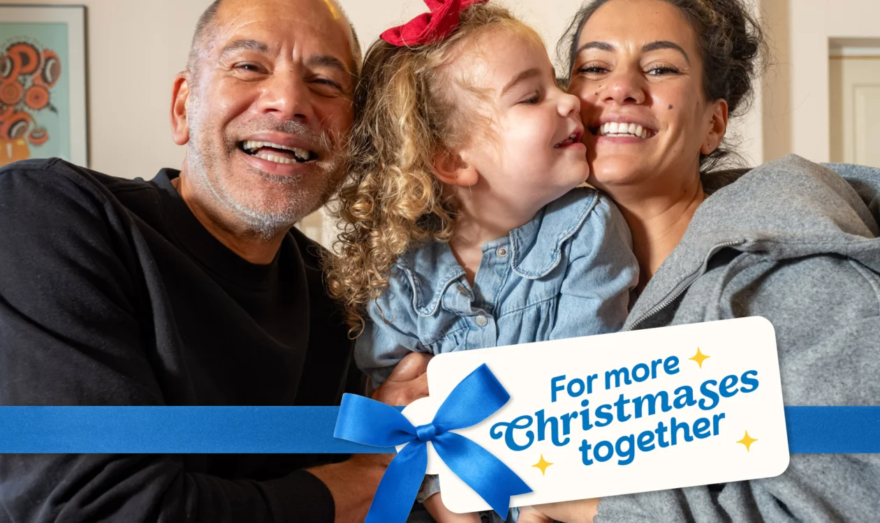 An older man, younger lady and a little girl all embrace and smile together