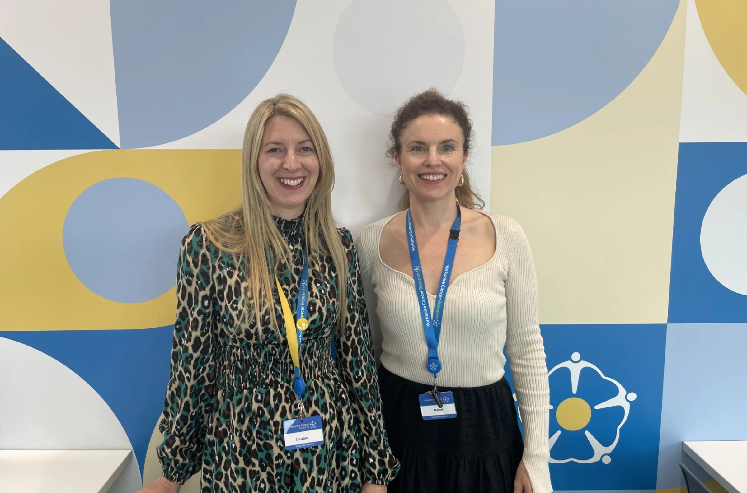 Two ladies in lanyards pose for a photo