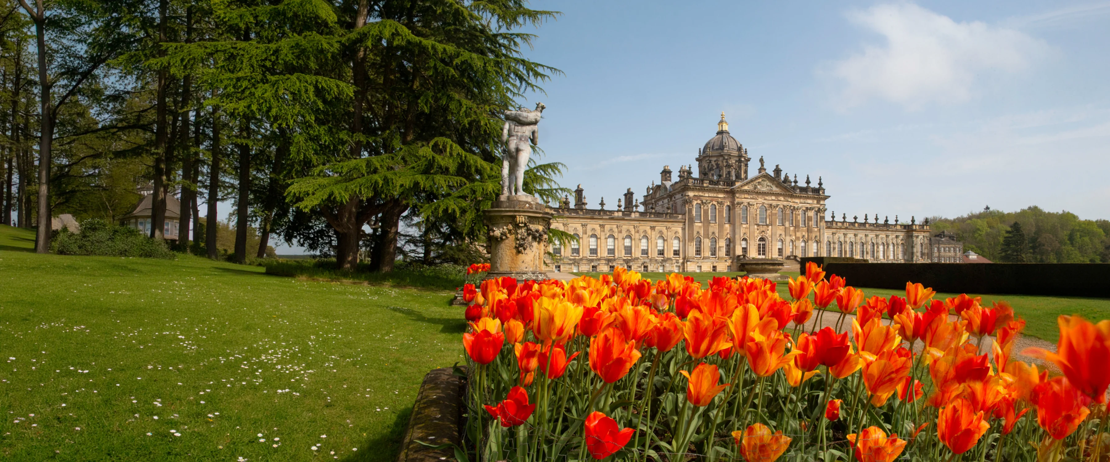 Castle Howard on a bright day with colourful tulips in the foreground