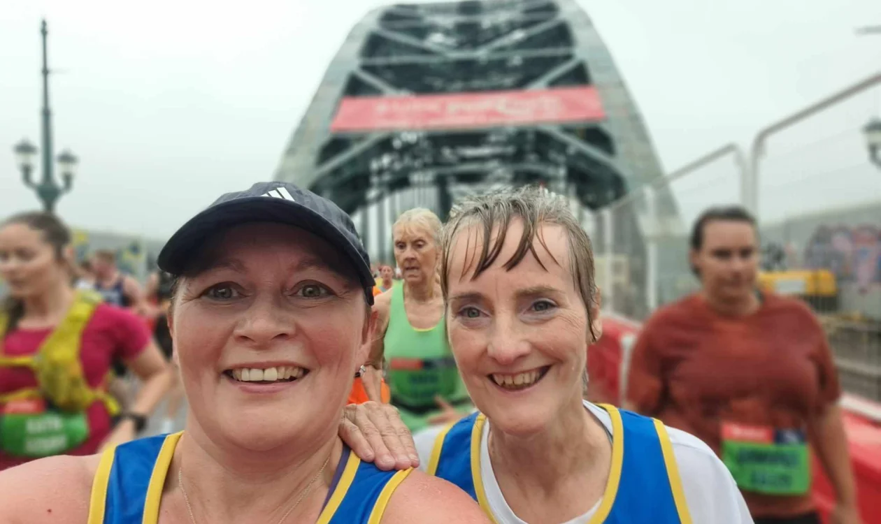 Two women take a selfie whilst running on the Tyne bridge