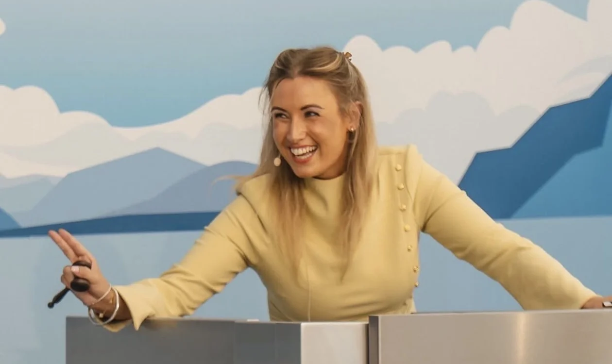 A lady stands at an auctioneers podium