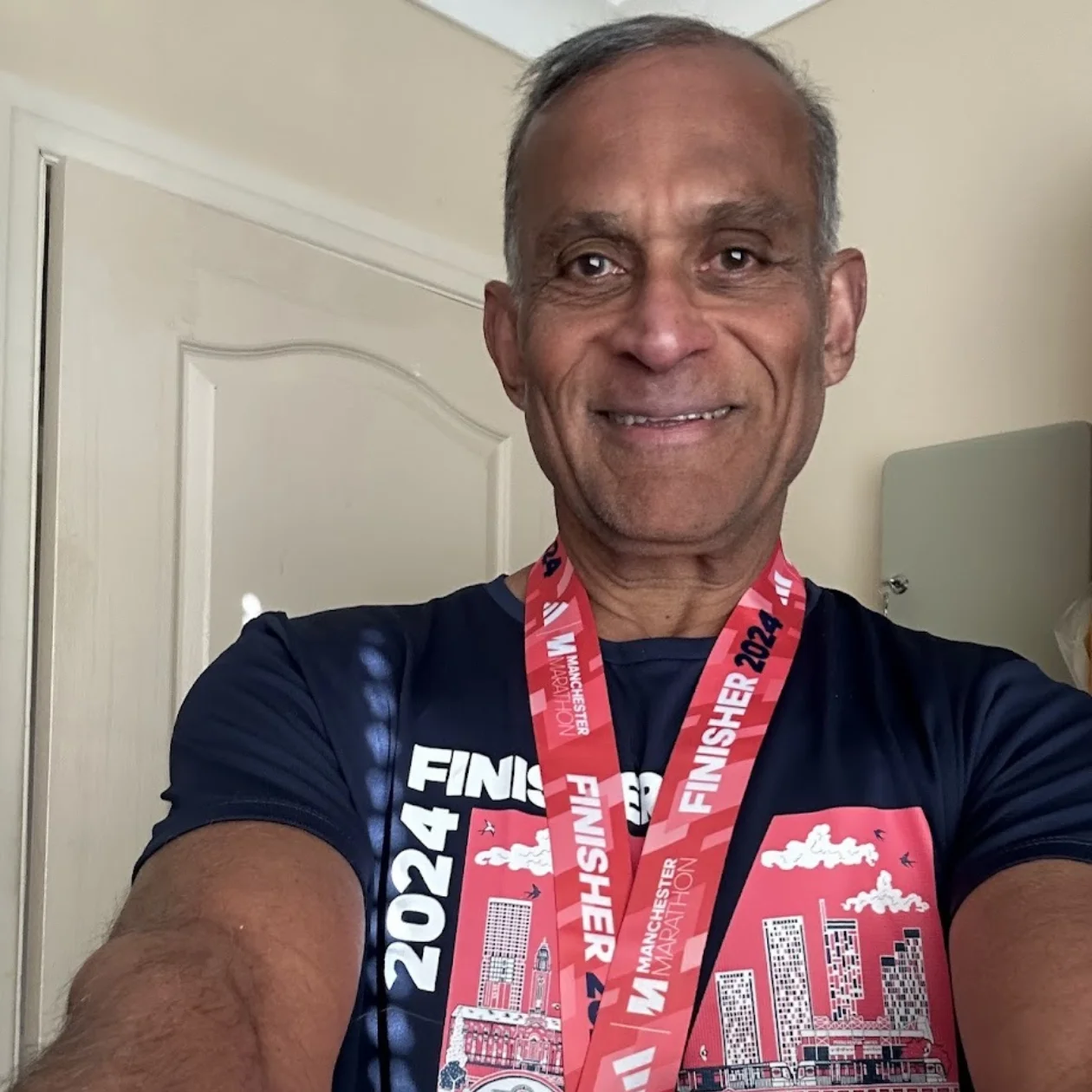 A man takes a selfie with his finishers medal