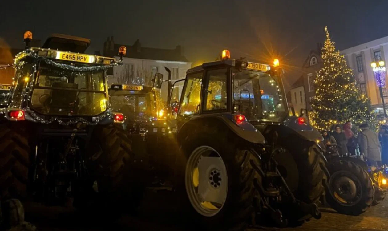 2 Tractors decorated in Christmas lights on a dark winter night
