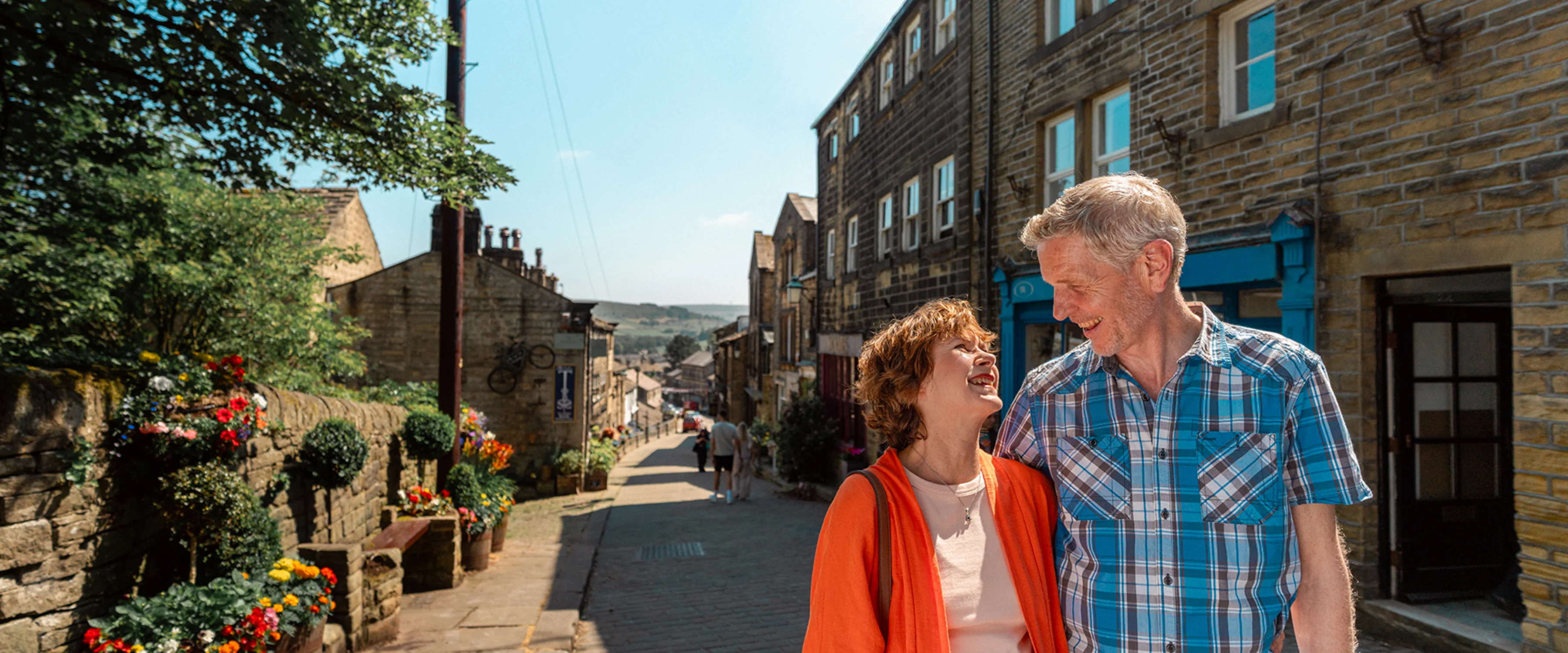 Male and female looking at each other while walking down a scenic Yorkshire street