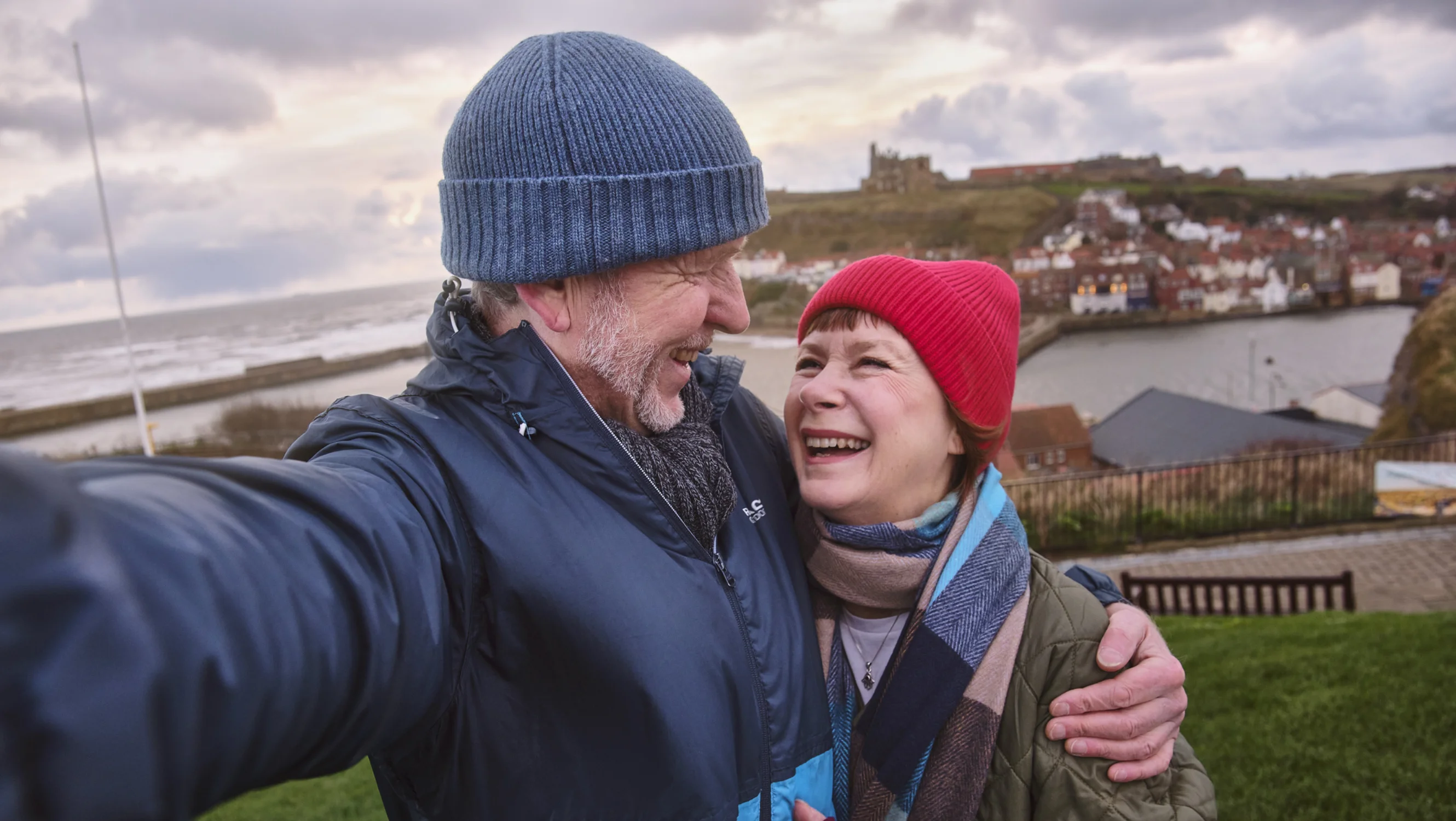Rob and his partner, talking a selfie with the Whitby harbour area as backdrop.