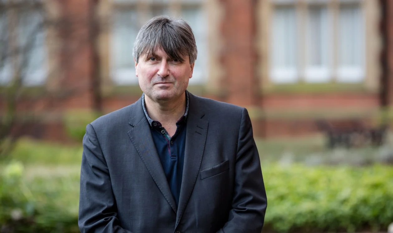 Poet Laureate, Simon Armitage, standing outside in front of an old building