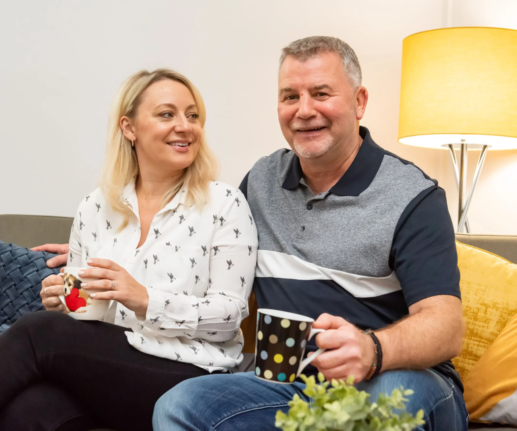 A couple smiling on a couch