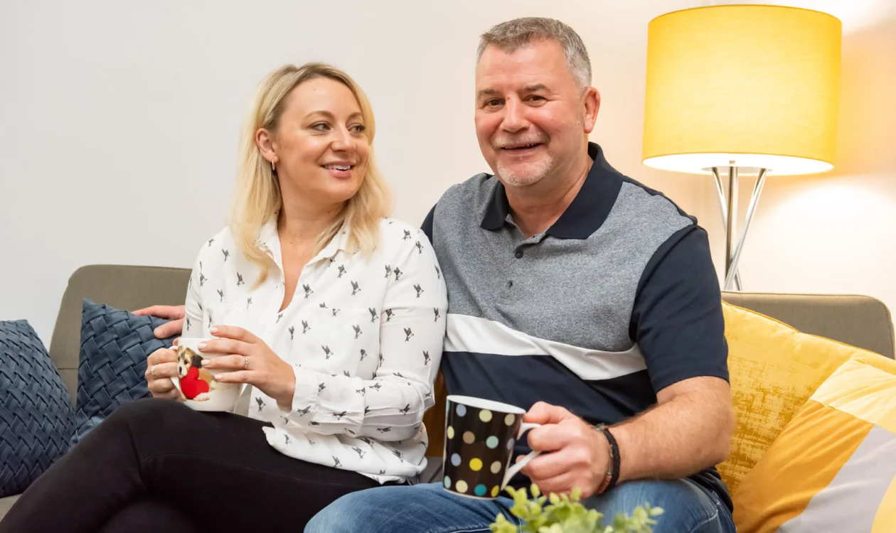 A couple smiling on a couch