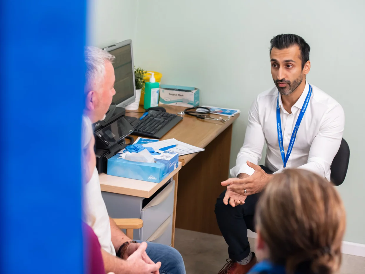 Doctor in discussion with patient and their partner in GP practice
