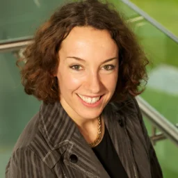 A lady with a curly bobbed haircut smiling