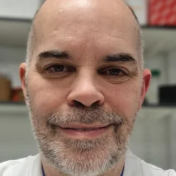 A man with a grey beard smiling