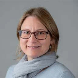 A lady with glasses and bob smiling