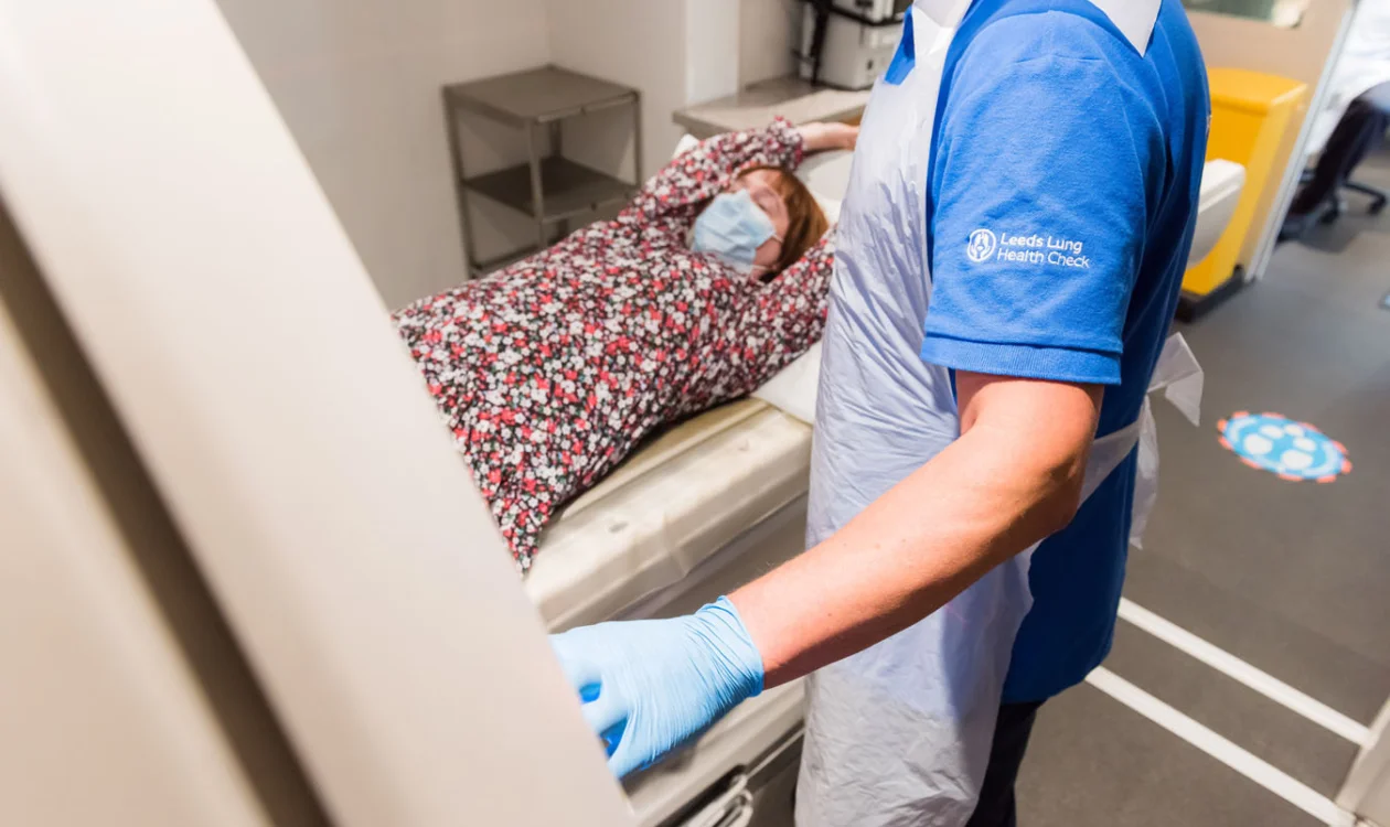 Clinican overseeing a female patient having a CT scan