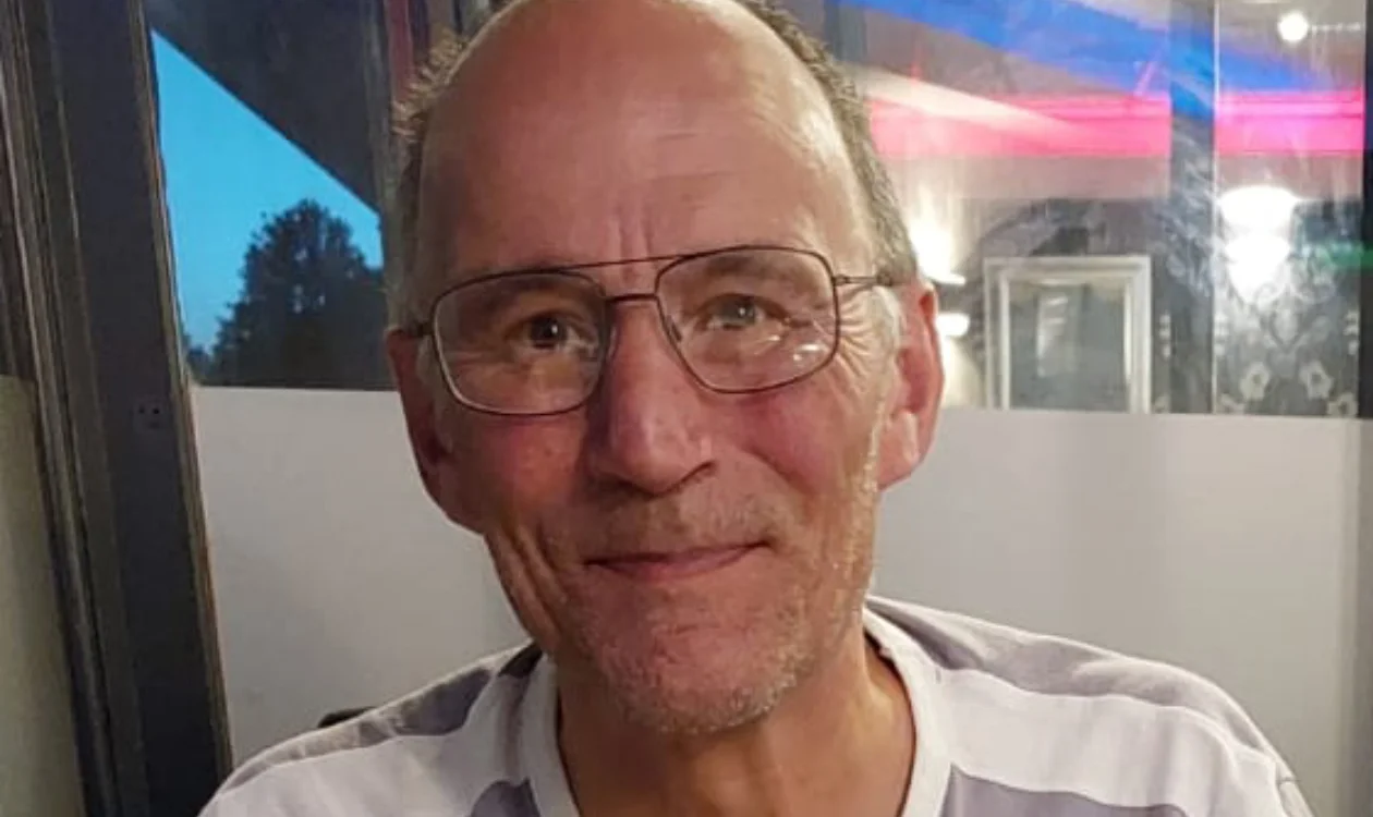 A man with glasses smiling