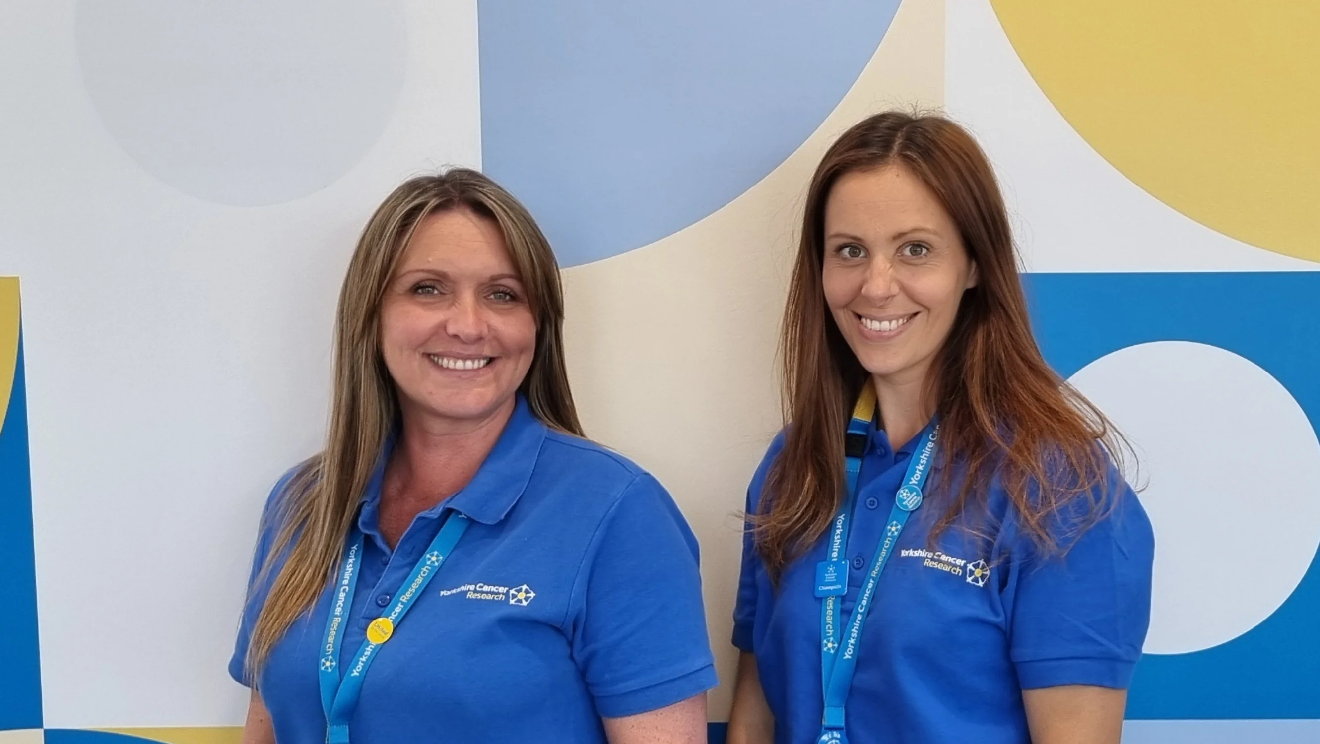 two women standing together and smiling